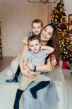 güzel anne kanepede onu iki oğlu kucaklıyor