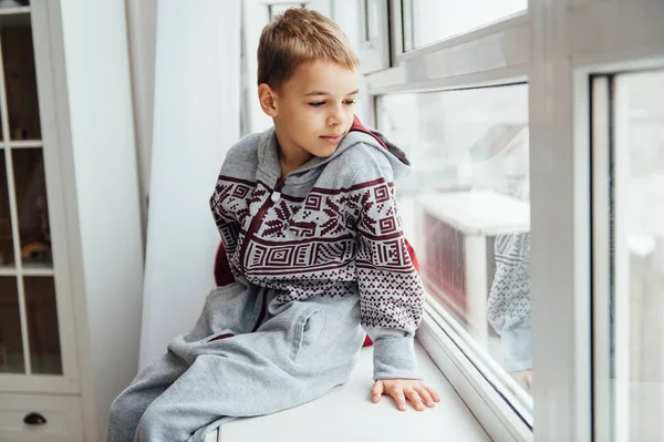 Дуже мила і красива дитина в піжамі, що сидить біля вікна . — стокове фото