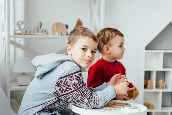 Два брати грати головоломка на стіл в скандинавському стилі, кімнати дитячі — стокове фото