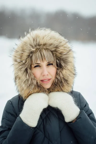 Schönes Winterporträt einer jungen Frau in der verschneiten Winterlandschaft — Stockfoto