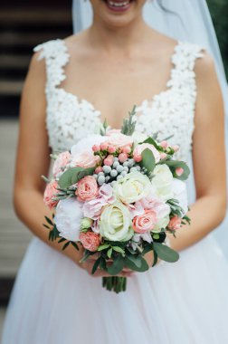 Gelin elleri güzel bir düğün buketi tutuyor.