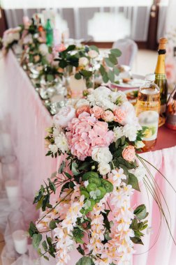 Gelin ve damat için kumaş ve çiçeklerle süslenmiş festival masası.