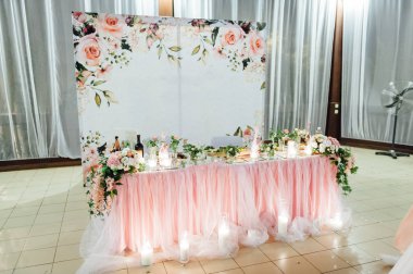 Gelin ve damat için kumaş ve çiçeklerle süslenmiş festival masası.