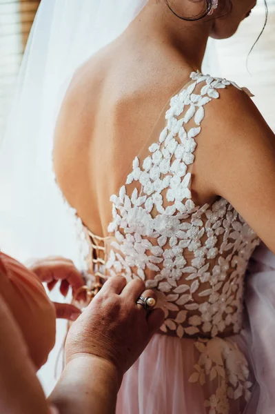 Damas de honra ajudam a usar um vestido de noiva — Fotografia de Stock