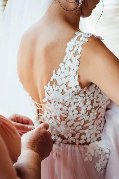 Damas de honra ajudam a usar um vestido de noiva — Fotografia de Stock