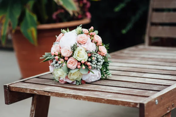 Svatební kytice s růží na dřevěnou lavici — Stock fotografie