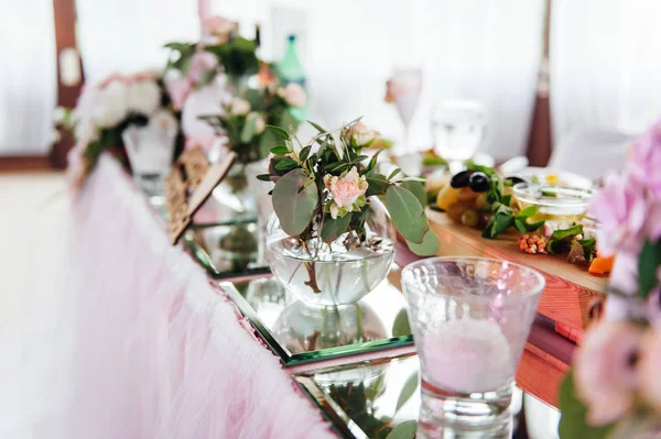 Festligt bord för bruden och brudgummen dekorerad med tyg och blommor — Stockfoto