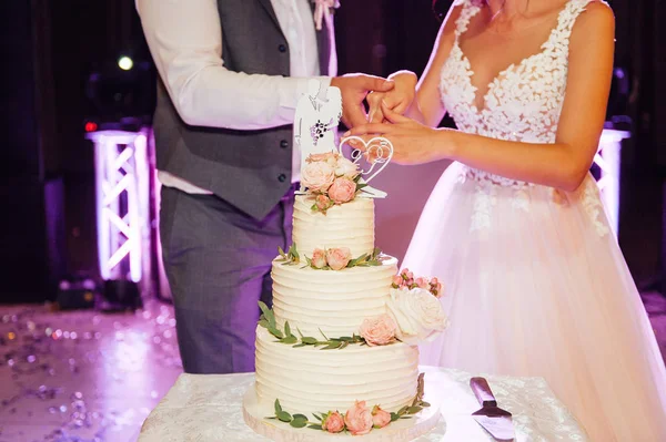 Церемония свадьбы. Жених и невеста режут торт — стоковое фото