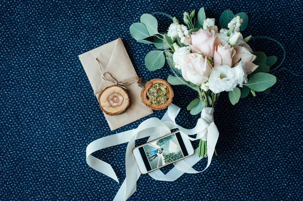 Bruiloft boeket met ringen, houten kist voor ringen, smartphone — Stockfoto