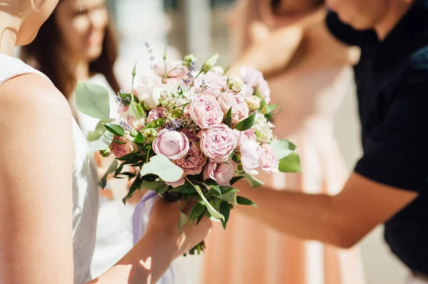 Bruid houdt een bruiloft boeket, trouwjurk, bruiloft details — Stockfoto