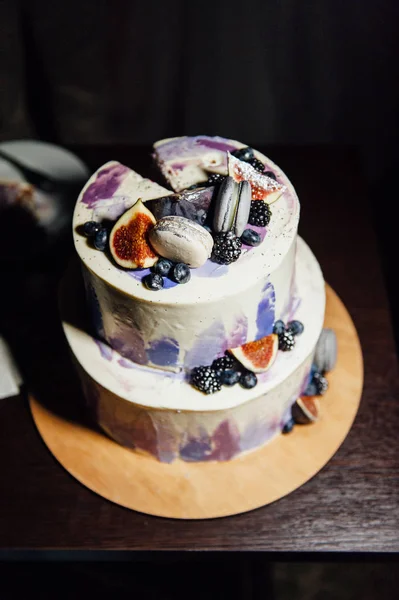 Les mariés ont coupé un beau gâteau blanc de mariage décoré de baies — Photo