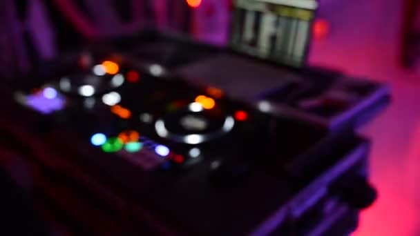 Ο Dj στο disco λειτουργεί πίσω από το τηλεχειριστήριο. Πάτωμα χορού και ελαφριά μουσική. — Αρχείο Βίντεο