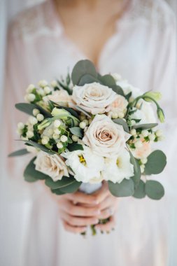 Onu düğün buket tutan bir bornoz içinde gelin