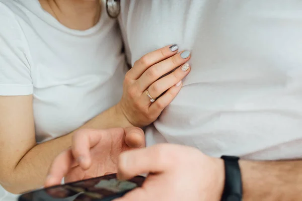 Lachende junge Leute im Schlafanzug posieren verspielt auf dem Sofa. glückliches Paar lächelt am Morgen — Stockfoto