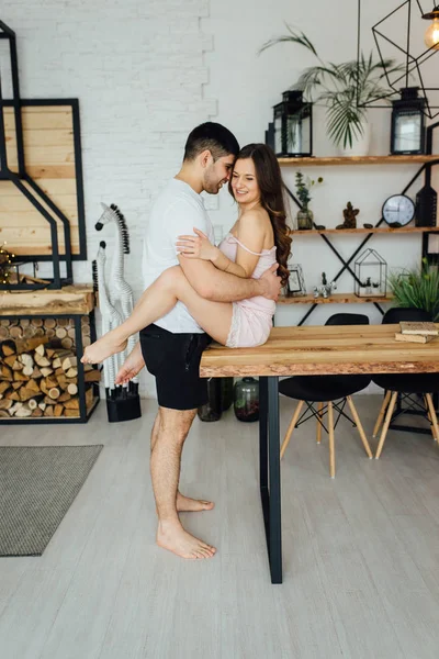 Lyckliga älskande par sitter på ett träbord. De är lyckliga och njuta av varandra — Stockfoto
