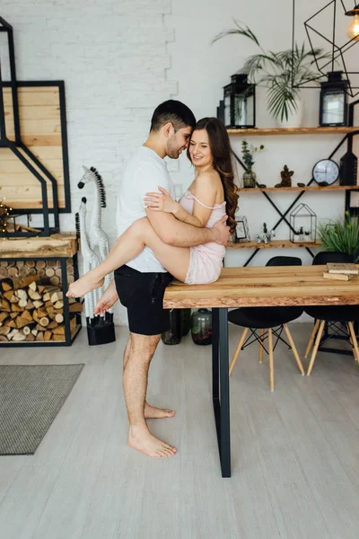 Feliz pareja amorosa sentada en una mesa de madera. Son felices y disfrutan el uno del otro — Foto de Stock