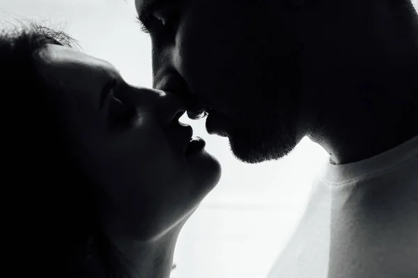 Paar küsst sich am Fenster. Mann und Frau in der Dunkelheit. süßer Geschmack deiner Lippen — Stockfoto