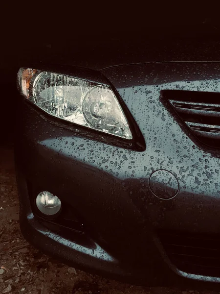 Car headlight and bumper premium car with raindrops — Stock Photo, Image