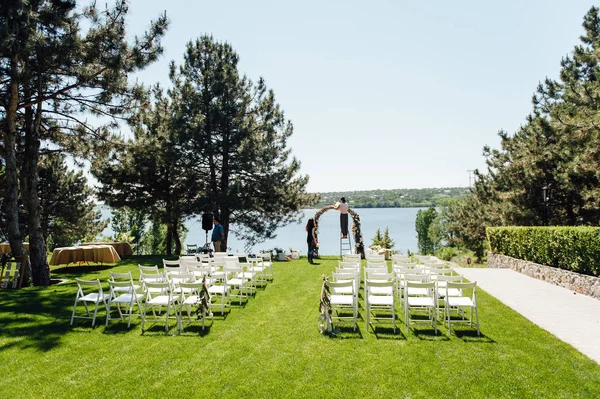 Arco bonito para a cerimônia de casamento no parque com cadeiras brancas para convidados — Fotografia de Stock