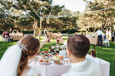 . Gelin ve damat şampanya kadehlerini kızartıyor. Yakın çekim.