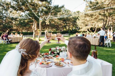 . Gelin ve damat şampanya kadehlerini kızartıyor. Yakın çekim.
