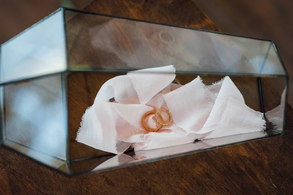 Deux alliances en or dans une élégante boîte en verre . — Photo