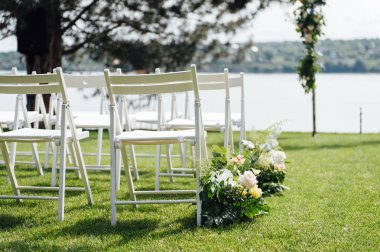 Giden düğün töreni. Dekor Stüdyosu. yeşil bir çim üzerinde beyaz ahşap sandalyeler.