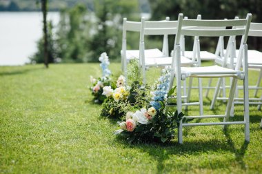 Giden düğün töreni. Dekor Stüdyosu. yeşil bir çim üzerinde beyaz ahşap sandalyeler.