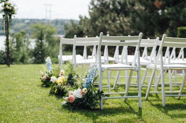 Giden düğün töreni. Dekor Stüdyosu. yeşil bir çim üzerinde beyaz ahşap sandalyeler.