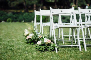 Giden düğün töreni. Dekor Stüdyosu. yeşil bir çim üzerinde beyaz ahşap sandalyeler.