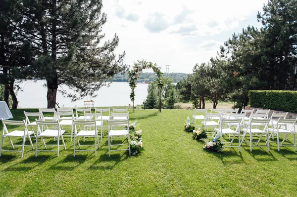 Giden düğün töreni. Dekor Stüdyosu. yeşil bir çim üzerinde beyaz ahşap sandalyeler.