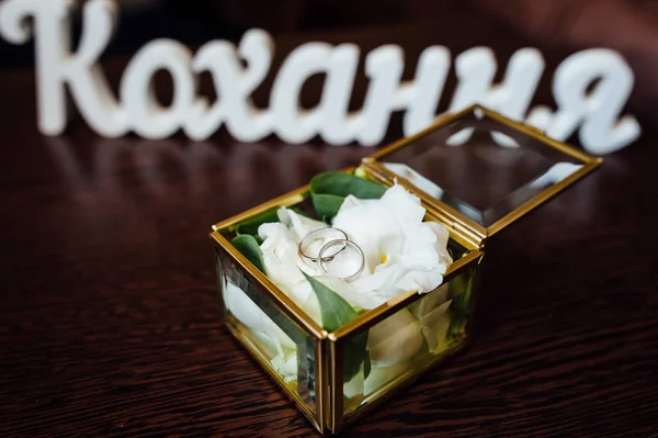 wedding rings in a glass box on the table for ceremonies