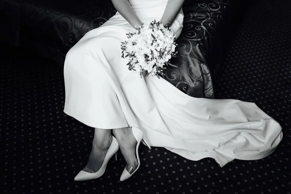 Όμορφη νύφη σε ένα φόρεμα βάζει τα άσπρα παπούτσια — Φωτογραφία Αρχείου