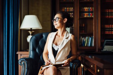 Çok güzel iş kadın bir ofis koltuğu oturur ve gelecek için onu iş planları