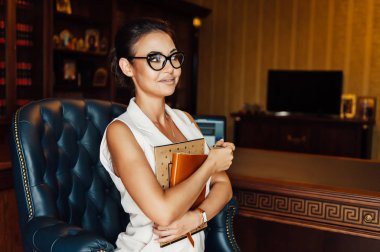 Çok güzel iş kadın bir ofis koltuğu oturur ve gelecek için onu iş planları