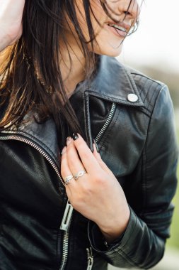 Siyah deri ceketli kız şehirde yürüyor