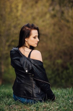 Siyah deri ceketli kız şehirde yürüyor