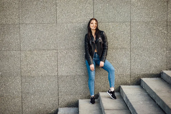 검은 가죽 재킷을 입은 소녀가 도시를 걷는다. — 스톡 사진
