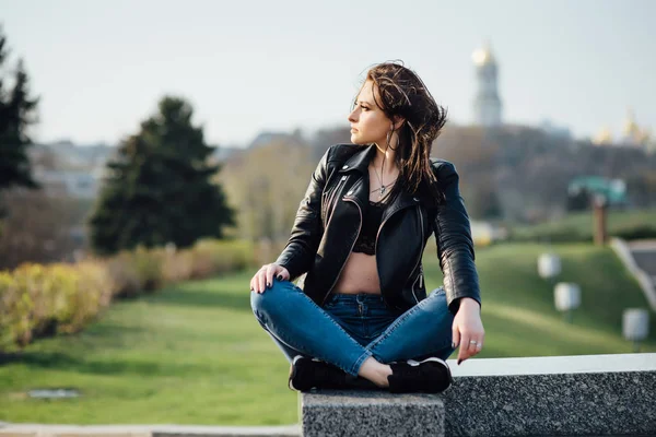 Menina em uma jaqueta de couro preto caminha pela cidade — Fotografia de Stock