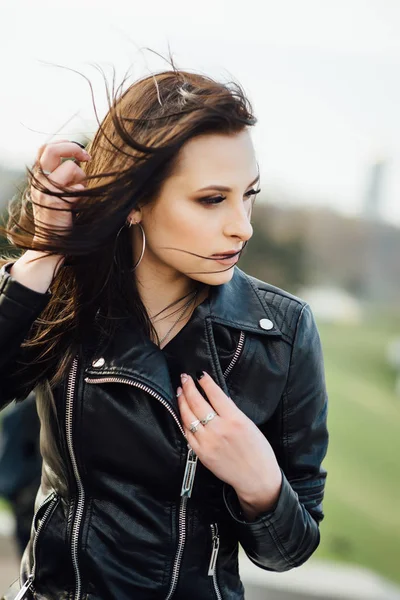 Menina em uma jaqueta de couro preto caminha pela cidade — Fotografia de Stock