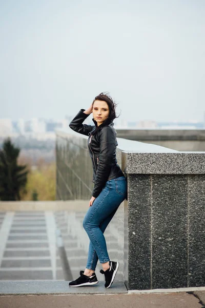 검은 가죽 재킷을 입은 소녀가 도시를 걷는다. — 스톡 사진