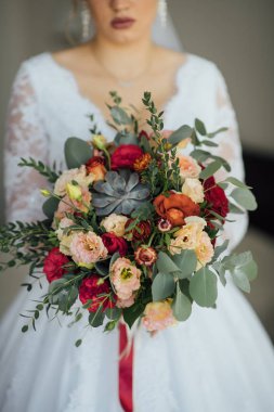 bir buket çiçek ve yeşillik holding beyaz bir elbise içinde gelin