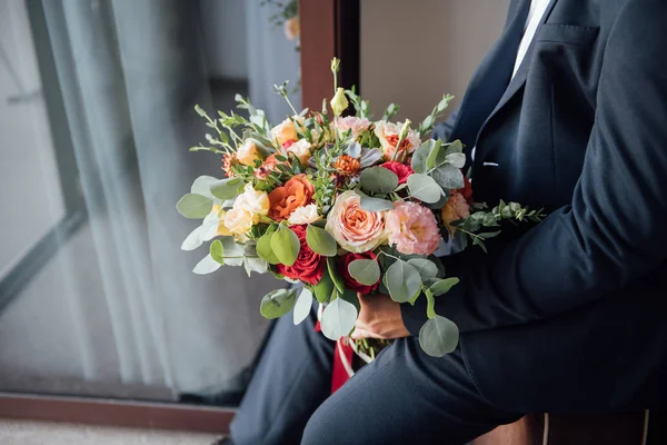 De bruidegom wacht op de bruid en houdt in handen een mooie bruiloft boeket — Stockfoto