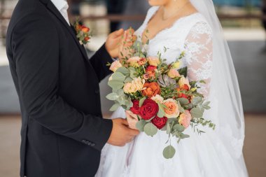 bir buket çiçek ve yeşillik holding beyaz bir elbise içinde gelin