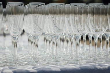 Masada bir sıra boş şampanya kadehi var. Ziyafet ayarı