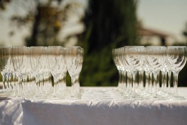 Masada bir sıra boş şampanya kadehi var. Ziyafet ayarı