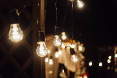 gece düğün töreni. Bir ampul çelengi. akşam cam şişeleri mumlar.