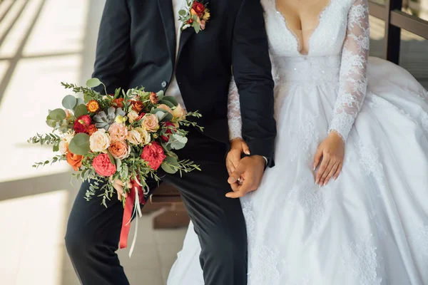 El novio espera a la novia y tiene en las manos un hermoso ramo de bodas —  Fotos de Stock