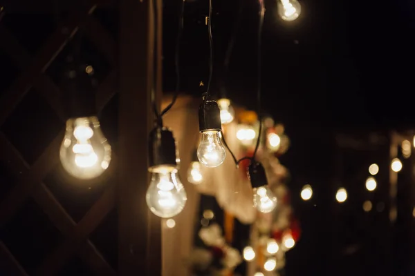 Ceremonia de boda nocturna. Una guirnalda de bombillas. velas en frascos de vidrio por la noche . — Foto de Stock