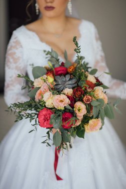 bir buket çiçek ve yeşillik holding beyaz bir elbise içinde gelin